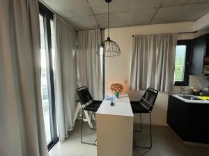 a kitchen with two chairs and a table with a sink at Luminoso Depto 40 metros NUEVO. Excelente Ubicacion Zona Sur. in Remedios de Escalada
