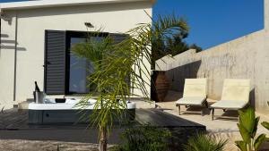 a bathroom with a tub and two chairs on a patio at Ek Ornelakis, Luxury Country House with Jacuzzi in Chania Town