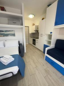 a small room with a bed and a kitchen at c'est la vie giardini in Giardini Naxos