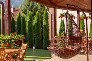 a hammock hanging from a gazebo in a garden at Pension Pantheon in Poiana Brasov