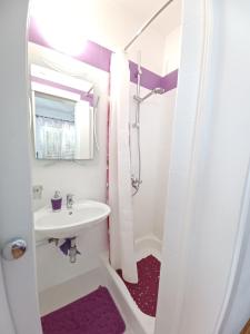 a white bathroom with a sink and a shower at Apartment Silvia in Makarska
