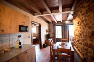 a kitchen and living room with a table and a couch at L'Olivera - BENABARRE in Benabarre