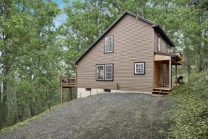 a house on top of a hill with a driveway at Valley Views Hot Tub Deck Screened Porch & WiFi in Hedgesville