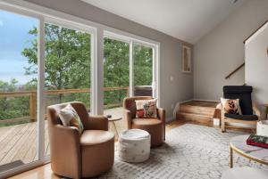 a living room with two chairs and large windows at Valley Views Hot Tub Deck Screened Porch & WiFi in Hedgesville +44 photos