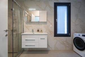 ニキティにあるSithoniaRS Avina Luxury Maisonetteのバスルーム(シンク、シャワー、洗濯機付)