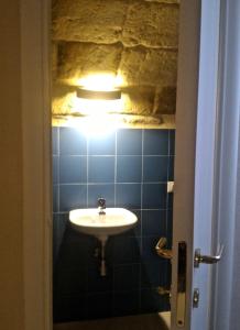 baño con lavabo y una luz en la pared en La Torre e il Mare Rooms, en Monopoli