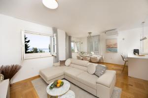 een woonkamer met een bank en een tafel bij Marivi - Luxury apartment above the beach Žnjan in Split