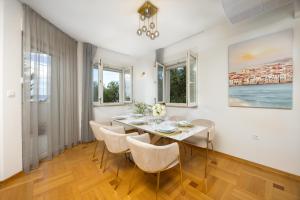 een eetkamer met een tafel en stoelen bij Marivi - Luxury apartment above the beach Žnjan in Split