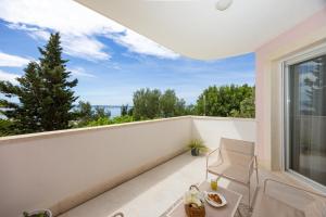 een wit balkon met een tafel en een stoel bij Marivi - Luxury apartment above the beach Žnjan in Split