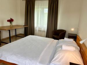 una camera da letto con un grande letto bianco e una scrivania di Luxor a Havířov