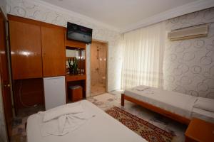 a room with two beds and a tv on the wall at deniz apart hotel in Kuşadası