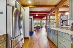 a kitchen with a stainless steel refrigerator and a dining room at Splendor On The Lake in Center Harbor