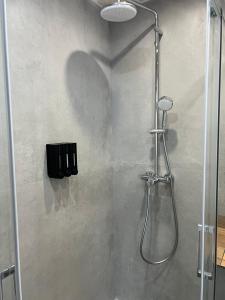 a shower with a glass door in a bathroom at Mistral Suites in Valencia