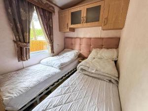 deux lits dans une petite pièce avec une fenêtre dans l'établissement 8 Berth Caravan For Hire At Wild Duck Holiday Park In Norfolk Ref 11269Mc, à Great Yarmouth 14 autres photos