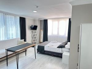 a bedroom with a bed and a table and a couch at Upart Flats by REFE in Antalya