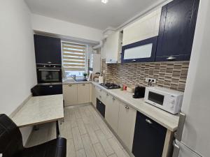 Una cocina con gabinetes blancos y encimera. en Cosy Place Milano, en Constanţa