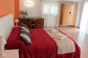 a bedroom with a red bed with two towels on it at Bed and Breakfast Dello Stretto in Villa San Giovanni