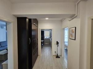 un pasillo con una puerta negra y una habitación en Cosy Place Milano, en Constanţa