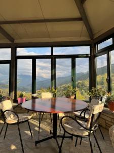 a table and chairs in a room with a view at Newly renovated 1 bedroom Flat in Tepelenë in Tepelenë