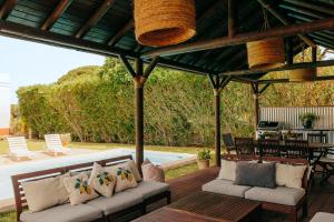 a patio with two couches under a pergola at Casa campo privada con piscina a 15 min playas Dehesa de las Yeguas in Cádiz