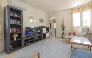 Una sala de estar con un televisor de pantalla plana y un sofá. en Stunning Home In Rojales With Kitchen, en Rojales