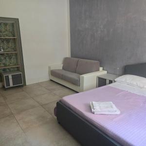un dormitorio con una cama y un sofá en Le Dame, en Verona