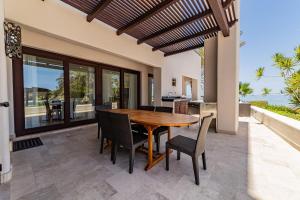 a dining room with a wooden table and chairs at Luxury Oceanfront Condo at El Caimancito Beach in La Paz