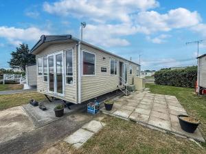 a tiny house is parked in a yard at Lovely Caravan With At Steeple Bay Park, Essex Ref 36016F in Southminster
