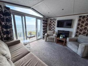a living room with a view of the ocean at Stunning Caravan With Full Sea Views At Hopton Haven Ref 80044S in Great Yarmouth