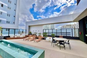 een patio met een tafel en stoelen en een zwembad bij Memoravel, Com Estilo e com gosto in Curitiba