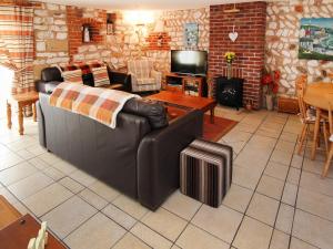 a living room with a leather couch and a tv at Seagull Cottage in Flamborough