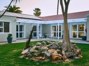 a palm tree in front of a house at Ocean House Swakopmund in Swakopmund