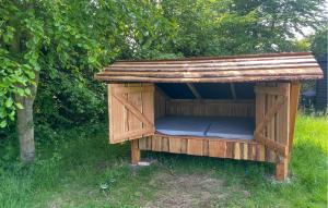 a wooden dog house with a roof in the grass at 3 Bedroom Gorgeous Home In Kalundborg in Kalundborg