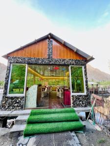 a house with a green rug in front of it at Riverfront resort sooq valley in Dargai
