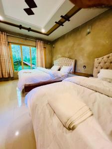 a bedroom with three beds in a room at Riverfront resort sooq valley in Dargai