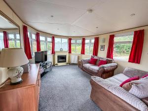 un soggiorno con due divani e una televisione di Great Dog Friendly Caravan To Hire With Field Views In Norfolk Ref 10132B a Belton