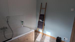 a bathroom with a bath tub and a wooden ladder at Spa Chambres d'hôtes in Spa