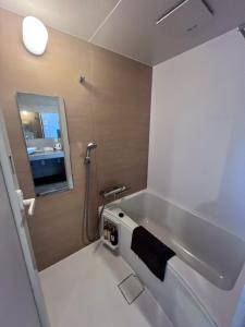 a bathroom with a bath tub with a black towel at Condominio Makishi Annesso in Naha