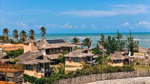 a group of houses with the ocean in the background at Tatadise in Tatajuba