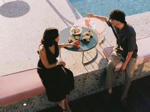 米兰21 House of Stories Navigli的坐在餐桌旁吃食物的男人和女人