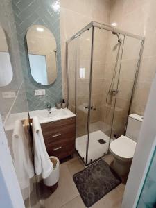 a bathroom with a shower and a toilet and a sink at Apartamento patio Andaluz in Rota