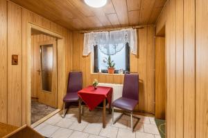 a dining room with a red table and two purple chairs at Ferienhaus Harzvorland in Frose
