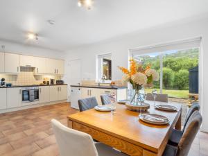 a kitchen and dining room with a wooden table and chairs at Cuirt Haven Clifden in Clifden