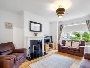 a living room with two couches and a fireplace at Cuirt Haven Clifden in Clifden