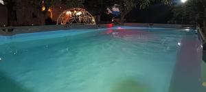 a swimming pool with blue water at night at Country Chic Antico Casale - piscina idromassaggio lettini, solarium, cinema experience, wifi, parcheggio in Caiazzo