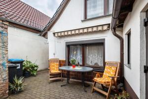 a patio with a table and chairs and a window at Ferienhaus Harzvorland in Frose
