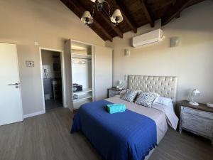 a bedroom with a bed with a blue comforter at Casa Marina - Casa frente a Luna Roja en Chapadmalal para 8 PAX - Hola Sur in Chapadmalal