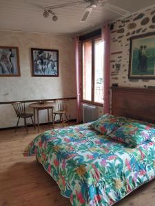 een slaapkamer met een bed en een tafel met stoelen bij Chambres d'hôtes Las Tanes in Vinça
