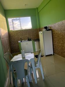 eine Küche mit Tisch und Stühlen und einem Kühlschrank in der Unterkunft Orla Flats - Apartamento 04 in Bragança