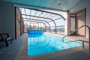 an indoor pool with a glass ceiling and blue water at L'Olivera - BENABARRE in Benabarre